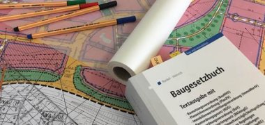 Symbolbild Stadtplanung Symbolbild für die Stadtplanung mit Gesetzbuch und Zeichenmaterial