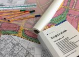 Symbolbild Stadtplanung Symbolbild für die Stadtplanung mit Gesetzbuch und Zeichenmaterial