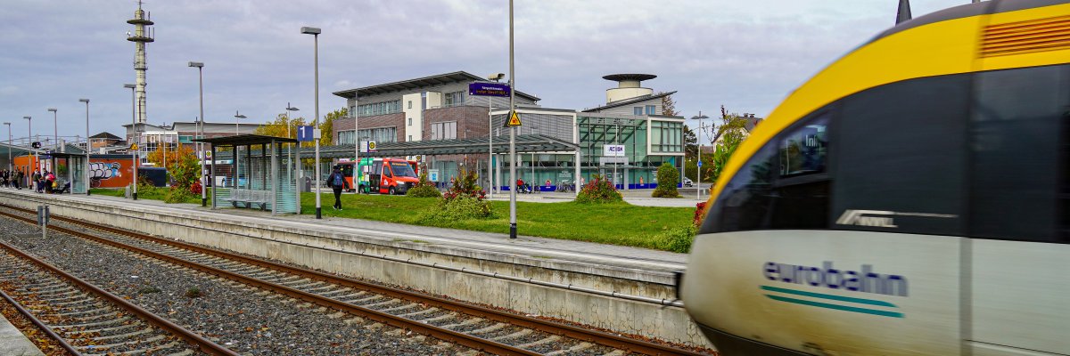 Warendorf Bahnhof Hier ist der Warendorfer Bahnhof mit einem hereinfahrenden Zug sowie Bussen im Hintergrund abgebildet.