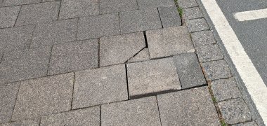 Gehwegschäden Beschädigte Gehwegplatten mit fehlender Bettung.